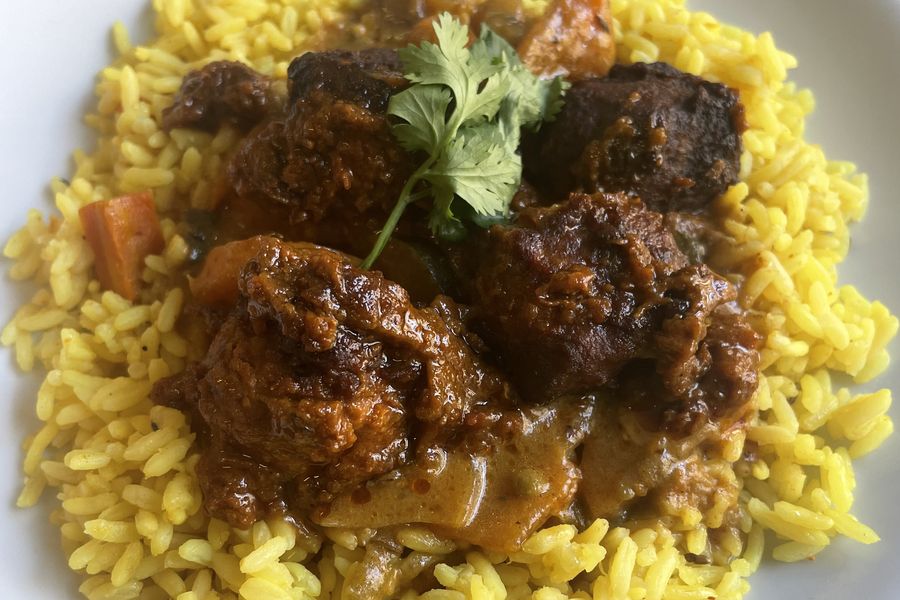 Boulettes de bœuf en sauce sur du riz safrané, avec de la coriandre